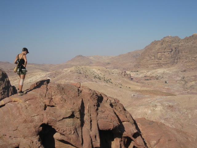 Kvinna står på klippa och blickar ut över ökenlandskap i Jordanien